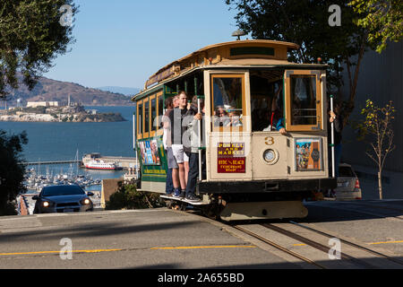 SAN FRANCISCO, USA - OKTOBER 2, 2019: Menschen reisen an der Powell und Hyde Seilbahn am Hyde Street mit Alcatraz Island, Fisherman's Wharf beh