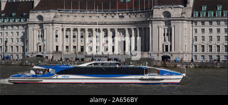Ein Fluss, mbna, Passagierschiff, auf der Themse in Westminster, London, stromaufwärts vor der City Hall an einem sonnigen Tag mit vielen Touristen Stockfoto