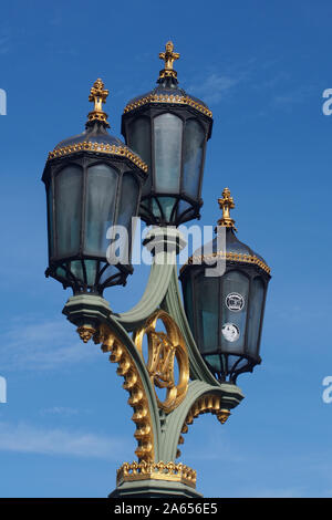 Drei Leuchten auf eine lam Post auf die Westminster Bridge, London zeigt die reich verzierten Detail im metallverarbeitenden und Lampen gegen den tiefblauen Himmel eingestellt Stockfoto