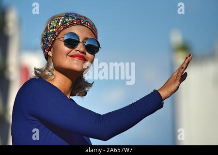 Junge Frau posiert Sonnenbrille tragen Stockfoto