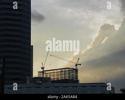 Umrahmt von einem Wolkenkratzer und über das Fullerton Hotel, das Gerüst Gerüst mit einem neuen Build Kontraste gegen die November himmel Singapur, 29. Nov 2004. Stockfoto