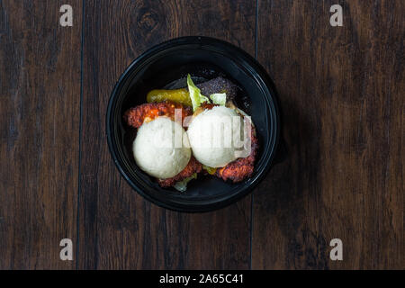 Nehmen Gua Bao Burger mit knusprigen Hähnchen und Red Hot Chili und Soße, Brötchen Relish in Kunststoff Platte Box Container/Paket. Fast Food. Stockfoto