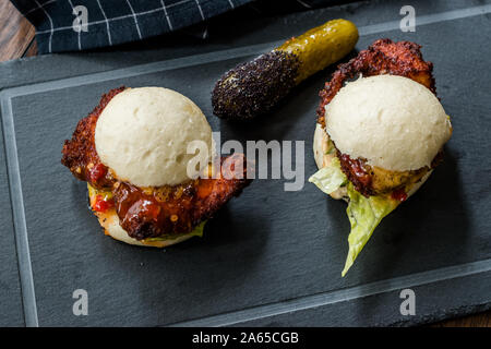Gua Bao Burger mit knusprigen Hähnchen und Red Hot Chilli Relish Sauce Brötchen. Fast Food. Stockfoto