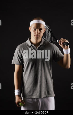 Portrait des jungen Mannes holding Schläger und Kamera über schwarzen Hintergrund Stockfoto