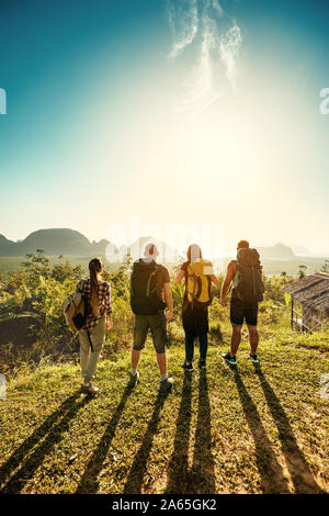 Vier Freunde Wanderer und Reisenden steht auf sunrise Sicht auf Meer und Inseln Stockfoto