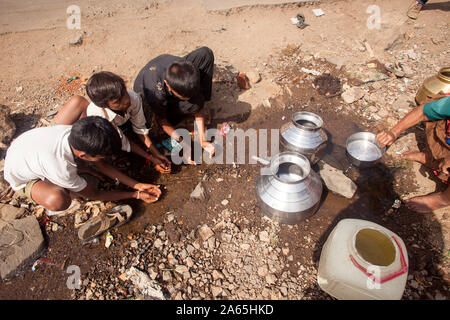 Kinder Trinkwasser aus Pfütze, Shahapur, Mumbai, Maharashtra, Indien, Asien Stockfoto