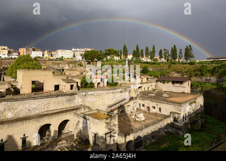 Ercolano. Italien. Regenbogen über den archäologischen Ausgrabungen von Herculaneum mit der alten Küstenlinie im Vordergrund. Stockfoto