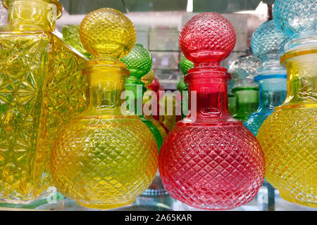 Gelb, Rot und Blau Dekanter close-up. Facettierte Dekanter in verschiedenen Farben und Formen in den Regalen der speichern. Haushaltswaren und Küchengeräte fo Stockfoto