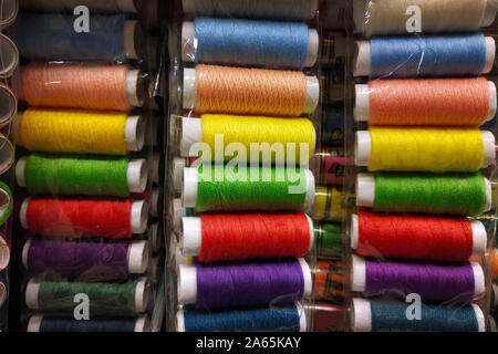 Mehrfarbige Nähgarne close-up. Knäuel Faden in verschiedenen Farben auf der Theke im Store. Threads zum Nähen. Stockfoto