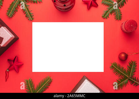 Sauberes Papier für Weihnachten Gruß text suddounded von Dekorationen auf rote Fläche. Flach, Ansicht von oben Komposition. Stockfoto