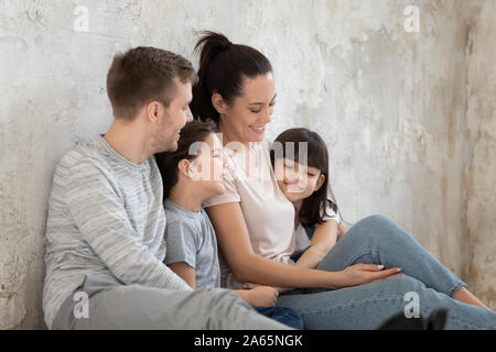 Freudige liebevolle Eltern umarmt lächelnde Kinder Geschwister. Stockfoto