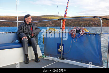 Ein älterer Mann auf einem Wildlife Bootsfahrt in den Klang der Raasay von Portree auf der Insel Skye, Schottland, Großbritannien, Europa. Stockfoto