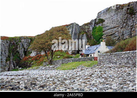 Eine Immobilie an der Rückseite einer steinigen Strand unter einer felsigen Klippe in Elgol, Isle of Skye, Schottland, Großbritannien, Europa. Stockfoto