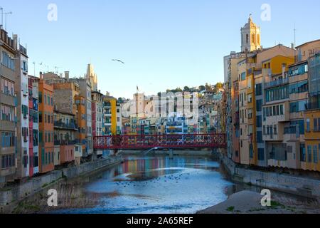 Girona, Spanien - Januar 23, 2019: Bunte und Häuser und die Brücke Pont de Sant Agusti im Fluss Onyar, in Girona, Katalonien, Spanien wider. Kirche von Stockfoto