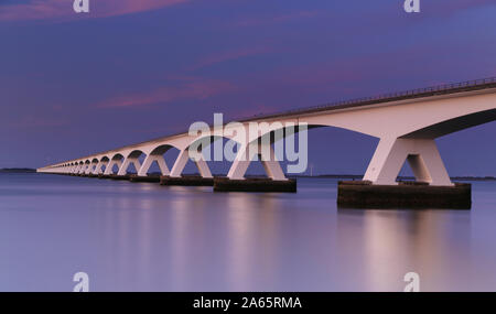 Lange Belichtung Sonnenuntergang über der Brücke Zeeland, Niederlande Stockfoto