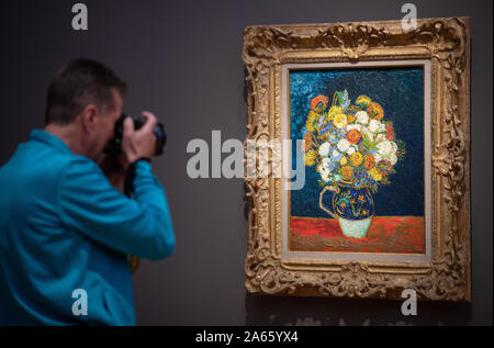 Potsdam, Deutschland. 24 Okt, 2019. Ein Mann fotografierte nach einer Pressekonferenz vor der Eröffnung der Ausstellung "Van Gogh. Immer noch Leben", die in das Museum Barberini: das Bild "Vase mit Zinnien'. Die Ausstellung zeigt 27 Stillleben des Künstlers und kann ab 26. Oktober 2019 bis 2. Februar 2020 gesehen werden. Credit: Monika Skolimowska/dpa-Zentralbild/dpa/Alamy leben Nachrichten Stockfoto