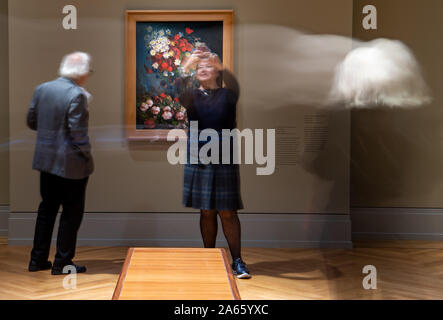 Potsdam, Deutschland. 24 Okt, 2019. Nach einer Pressekonferenz, Besucher stand vor der Eröffnung der Ausstellung "Van Gogh. Immer noch Leben", die in das Museum Barberini vor dem Bild "noch Leben mit Wiese, Blumen und Rosen" (Foto mit langen Exposition). Die Ausstellung zeigt 27 Stillleben des Künstlers und kann ab 26. Oktober 2019 bis 2. Februar 2020 gesehen werden. Credit: Monika Skolimowska/dpa-Zentralbild/dpa/Alamy leben Nachrichten Stockfoto