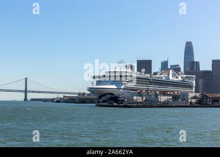 SAN FRANCISCO, USA - OKTOBER 2, 2019: Die Star Princess Kreuzfahrt Schiff angedockt in San Francisco Hafen und die Skyline der Stadt und die Bay Bridge. Stockfoto