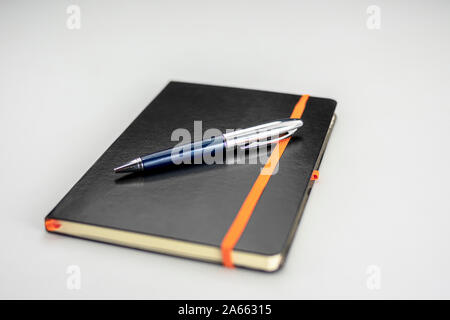 Gebunden notepad mit schwarzem Hardcover und moderne, in Blau und Silber pen Stockfoto
