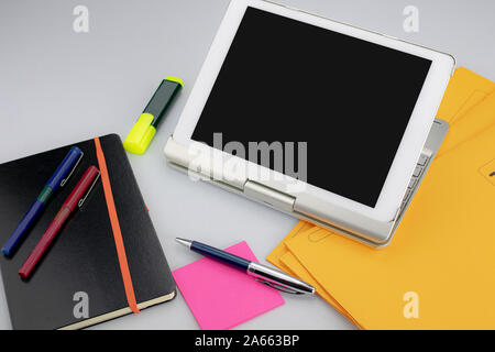 Bürobedarf bestehend aus Tablet PC mit Tastatur, fluoreszierenden Marker, rote und blaue Markierungen, moderne Pen, klebrige Notepad und Notiz Buch Stockfoto