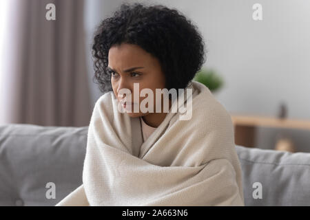 Ungesunde afrikanische amerikanische Frau in Decke sich unwohl fühlen abgedeckt Stockfoto