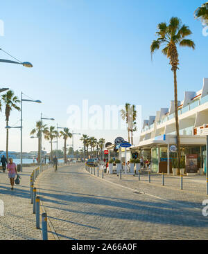 PAPHOS, RAUCHERREGELUNG - Februar 13, 2019: Menschen zu Fuß von Zypern Promenade bei Sonnenuntergang. Paphos - berühmte touristische Destination in Zypern Stockfoto