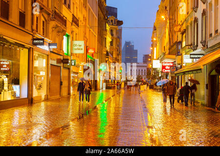 Brüssel, Belgien - Oktober 06, 2019: Menschen zu Fuß durch die Altstadt Einkaufsstraße von Brüssel im Regen in der Dämmerung Stockfoto