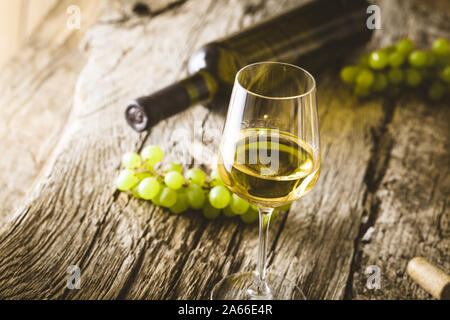 Wein. Glas Weißwein im Weinkeller. Alte Weißwein auf Holz. Stockfoto