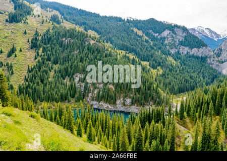 Bleiben Sie Kaindy versunkenen Wald See Atemberaubend malerischen Panoramablick auf die Hohe Betrachtungswinkel auf einem sonnigen blauen Himmel Tag Stockfoto