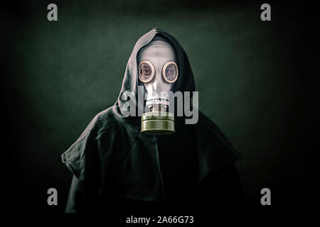 Mann in einem Gas Maske und Umhang mit Kapuze. Umwelt Umweltverschmutzung. Stockfoto