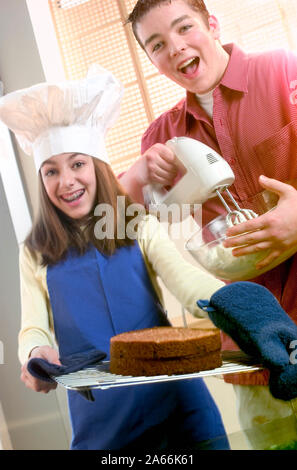 Porträt von zwei Teens Spaß beim Backen eines Kuchens Stockfoto