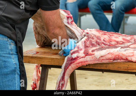 Schlachtung und traditionelle Herstellung der iberischen Schwein und extrahieren Sie verschiedene Teile der Iberischen Schwein 2019 iberischer Schinken Messe von Aracena Stockfoto