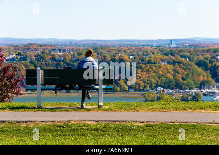 Quebec City, CA - 5. Oktober 2019 - Frau sitzen auf einer Bank am Levis Stadt von Ebenen von Abraham Stockfoto