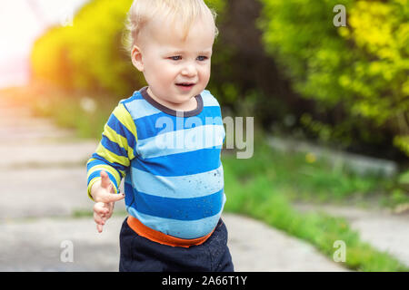 Süße kleine toddler Boy zeigt Mutter schmutzige Hände nach dem Spielen im Schlamm im Freien. Neugieriges Kind mit Schmutz oder Boden auf Palmen nach dem Entdecken der Welt Stockfoto