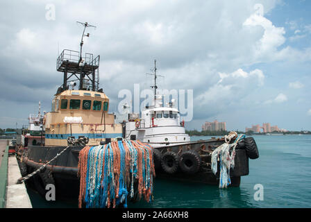 Die Ansicht von zwei Schleppern in Nassau Stadt Port mit Paradise Island günstig in einem Hintergrund (Bahamas). Stockfoto