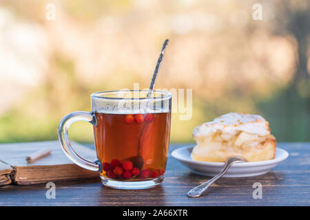 Kaffee Glas mit süßen Kuchen und Buch auf holztisch am Morgen, im Freien, Nahaufnahme Stockfoto