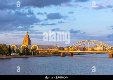 Akademie der Wissenschaften Gebäude, die Zentrale Markt- und der S-Bahn Brücke den Fluss Daugava, Riga, Lettland überschreiten Stockfoto