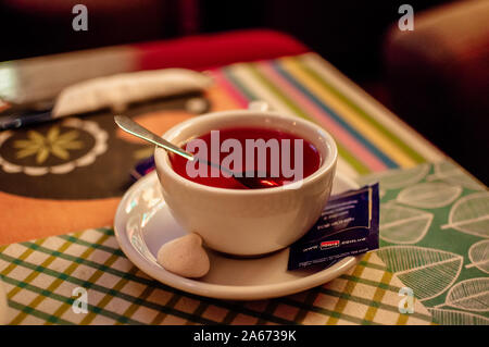 Weiße Tasse mit schwarzem Kaffee. Eine Tasse Kaffee steht auf einem hölzernen Tisch in einem Cafe. Das Konzept der eine gemütliche Zeit im Herbst ausgegeben. Stockfoto