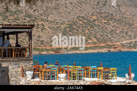 Plaka, Kreta, Griechenland. Oktober 2019. Essen und Trinken an der Waterfront zu einem tavernera in der Küstenstadt Plaka. Stockfoto