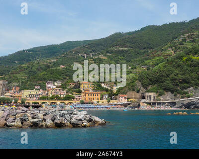 Cinque Terre Küste, Italien. Küste von Monterosso al Stute, Ligurien. Blick vom Mittelmeer, grüne Hänge von Bergen und Häusern am Wasser Stockfoto