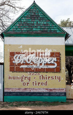 Was ist von einem alten Dr. Pepper trinken Werbeschild an der Wand eines Vintage Tankstelle an der Buffalo Gap Historic Village in unincorporated Taylor County, Texas, Stadt des gleichen Namens, in der Nähe von Abilene Stockfoto