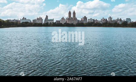 New York City Wolkenkratzer, vom Central Park im Herbst gesehen. See im Vordergrund, und die Leitung der Wolkenkratzer im Hintergrund. Stockfoto