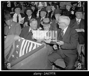 Wer geht in Washington, D.C., 21. April zu werfen. Wie die alte Linie Fans, dass sie sind, der Nation Nr. 1 Baseball Fans schauen Sie über das Programm zunächst auf ihre Plätze einnehmen. Senatoren Charles L. McNary von Oregon, und Carter Glas von Virginia, schauen Sie über das Line-up mit Vice President John Garner vor Beginn der heutigen Spiel zwischen den Washington Senatoren und die New York Yankees Stockfoto