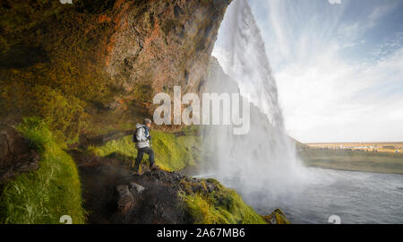 Wanderer Frau Suchen am Wasserfall Seljalandsfoss in Island Stockfoto