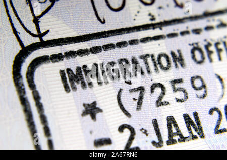 UK Eintrag Einreisestempel im Pass, wo die nur Buchstaben "EINWANDERUNG AUS' von Phrase die ganze 'Immigration Officer' sichtbar. Überzeugendes Konzept. Stockfoto