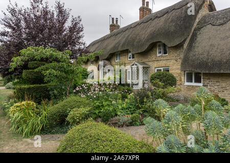 Ein Reetdachhaus in dem hübschen Dorf Ravenstone, Buckinghamshire, Großbritannien Stockfoto