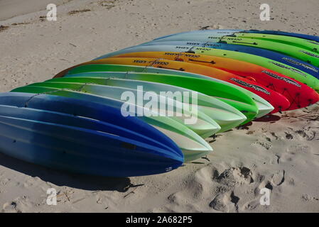 Bunte Plastikkajaks auf Strandsand. Stockfoto