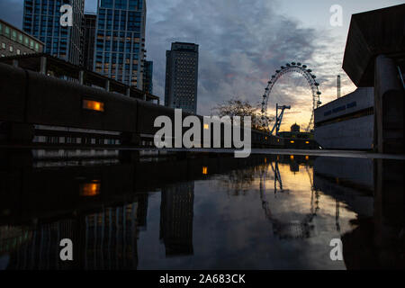 London Eye, spiegelt sich in einer Pfütze neben der Royal Festival Hal auf einem nassen Herbstabend, Southbank, London, England, Großbritannien Stockfoto