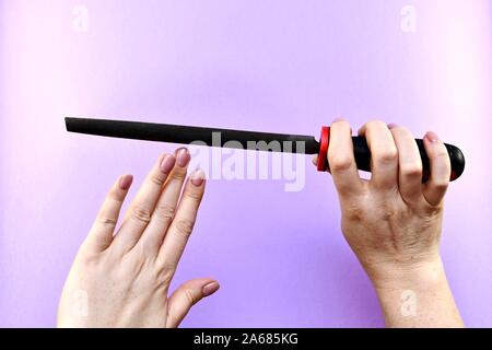 Weibliche Hände mit einer Datei, Maniküre, Nail File schneiden. Stockfoto