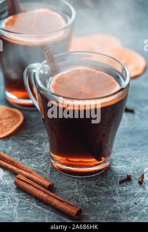 Weihnachten traditionelle heiße Getränke Glühwein mit Gewürzen und Orangenscheiben in einem Glas Tassen auf dem Tisch. Stockfoto